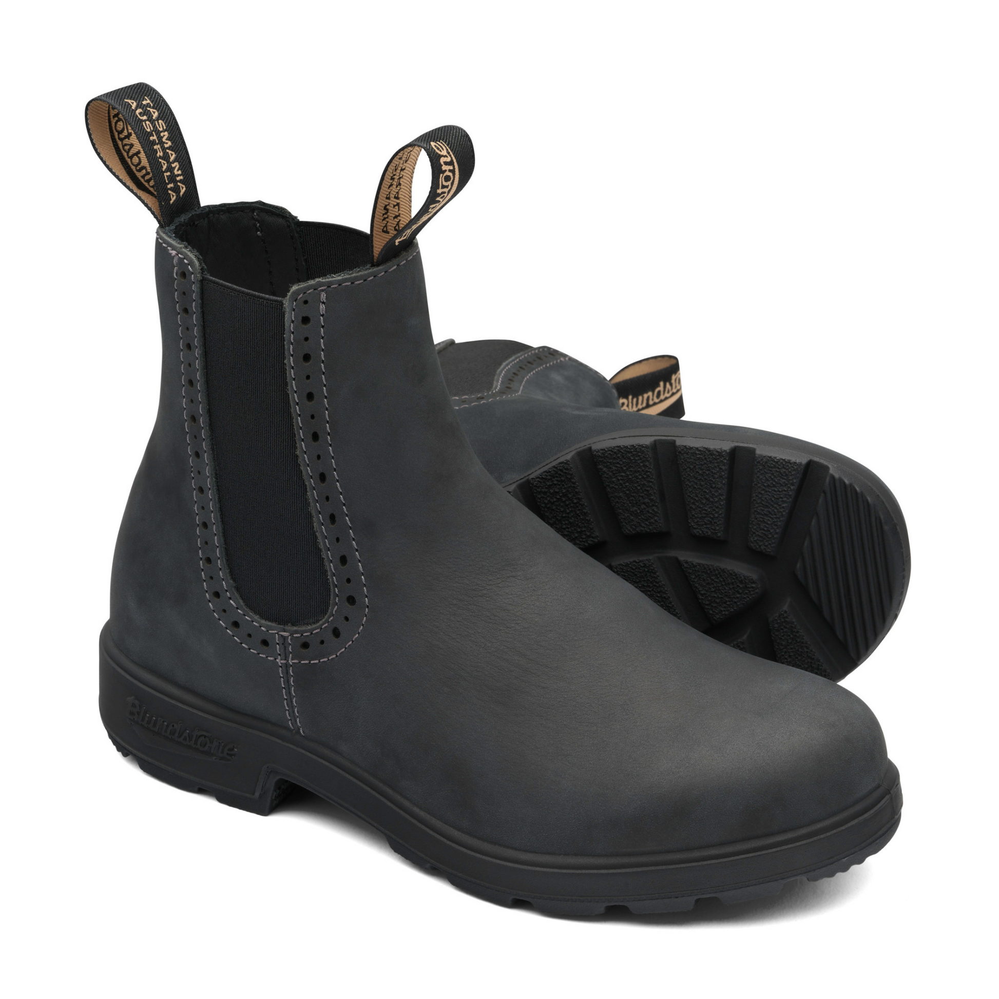 A pair of rustic black leather boots with black soles. Feminine broguing along the outer and inner ankle.