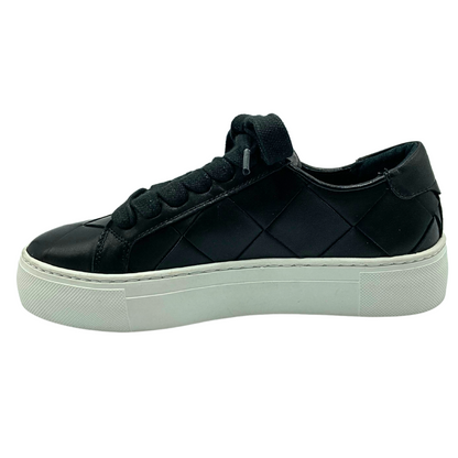 Inside view of a fashion sneaker in a woven black leather.  Soft white rubber sole