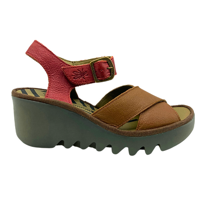 Outside view of wedge sandal.  Two-tone upper is tan in front and red at heel straps.  Open toe and heel.  Adjustable velcro under faux buckle
