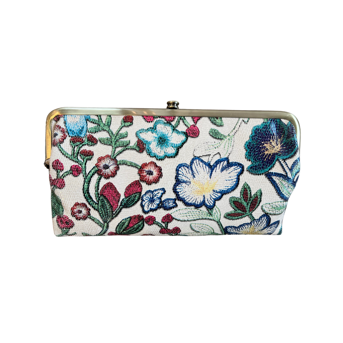 A wallet is shown in a floral stitch colour way. The flower colours are blues, reds, greens and yellow. The hardware is brushed antique brass.