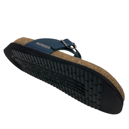 Underside view of the right sandal. Black sole, cork foot bed and blue straps. Silver embossed writing on the side of the strap that reads "Mephisto." 