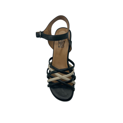 Top down view of a black sandal with cream strap details.  Open toe and heel.  Adjustable back strap