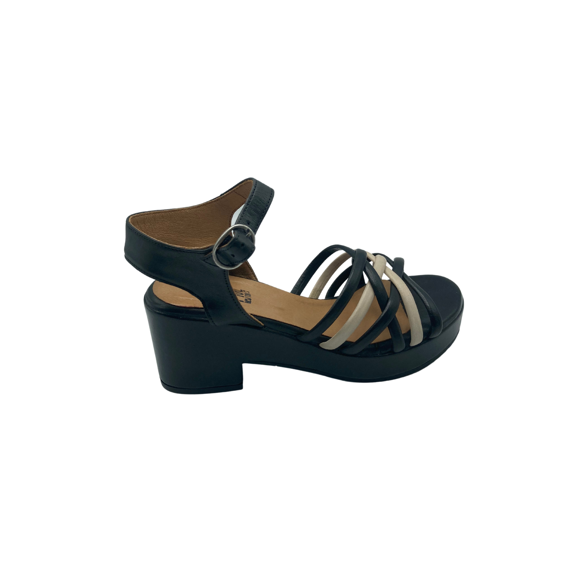 Angled side view of a low platform sandal.  Multiple thin straps criss-cross in front in black and cream.  Open toe and heel.  Wider heel and ankle strap with adjustable buckle.