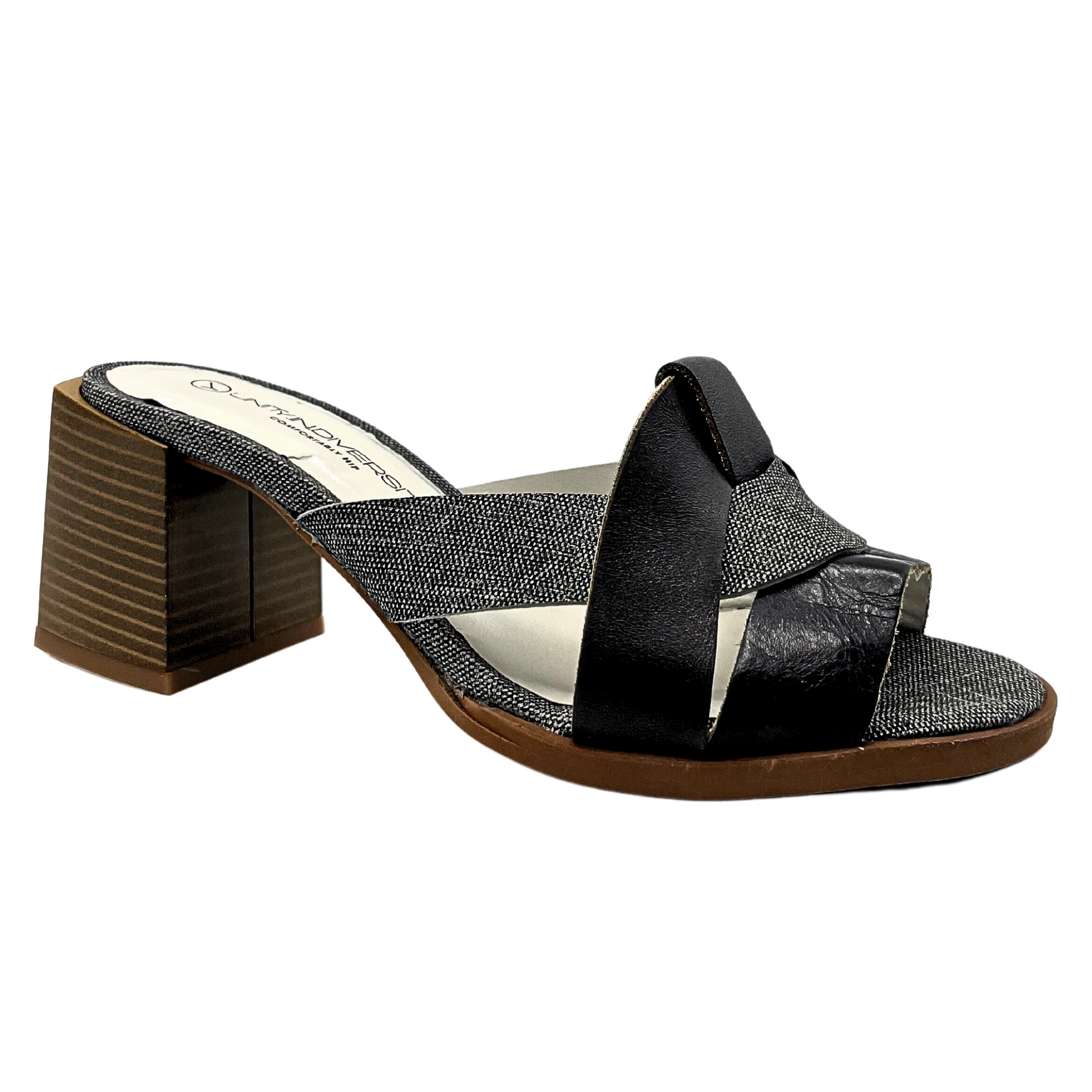 Angled side view of a lovelymule with a medium height stacked wood heel.  Smooth black leather is woven with a patterned black/white for a beautiful contrast