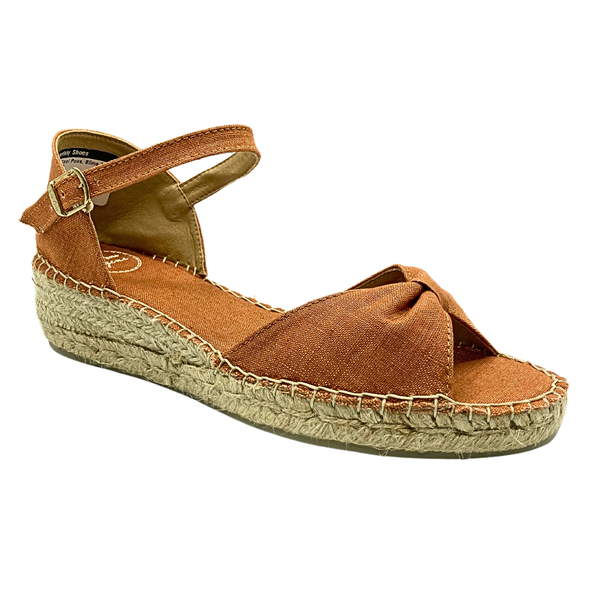 Angled side view of a simple espadrille sandale.  Puckered bow in front with open toe.  Heel is closed but there is an adjustable ankle strap.  Low wedge heel