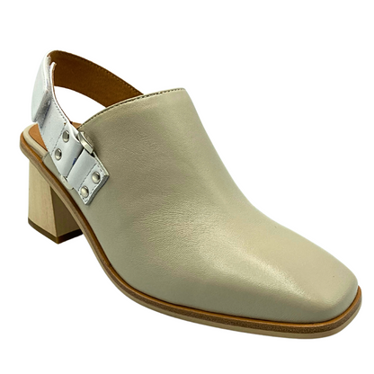 Angled front view of a closed toe shoe with an open heel and back strap.  Front feels a bit like a boot then the back is more sandal.  Taupe leather with a white leather strap at heel