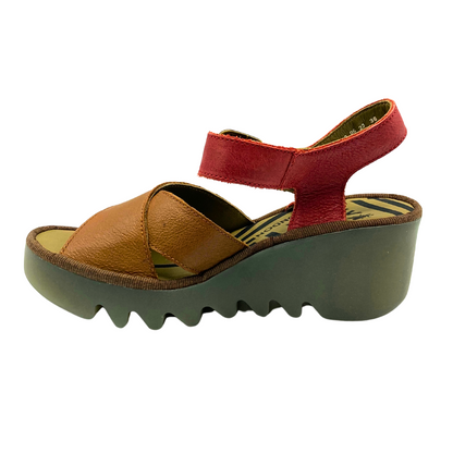 Inside view of wedge sandal with open toe and heel.  Cross straps in front done in a tan, heel and ankle straps in red