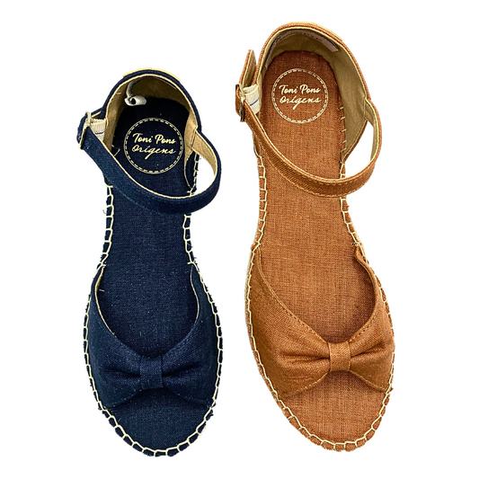 Top down view of a cute and casual espadrille sandal shown in navy and a paprika color.  Simple upper is a puckered bow at teh front.  Closed in heel with an ankle strap