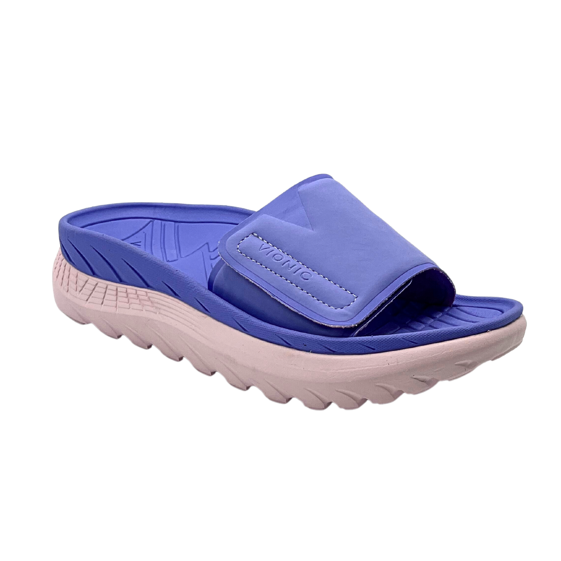 Angled side view of a fun beach slide.  Two-tone with a dark lilac on the top and a soft pink outsole.  One wide strap at front with a velcro adjustment
