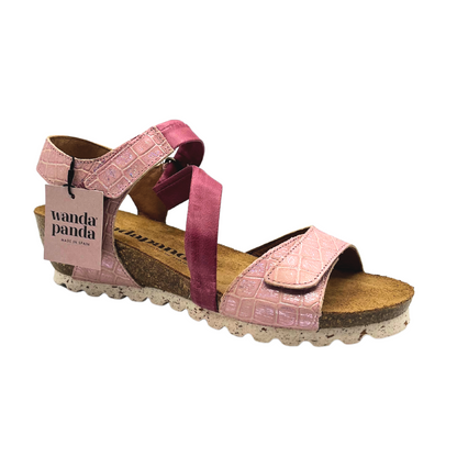 Outsie view of a low wedge sandal in a pink croco leather.  Front strap has an adjustable velcro tab.  Cross strap is connected to ankle strap.  Velcro tab on ankle strap adjusts both ankle and cross strap.