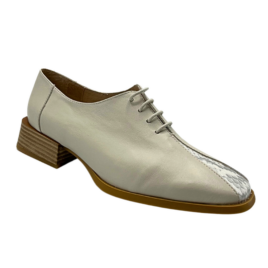 Angled side view of a tailored loafer in a light taupe with faux snakeskin sliver down the front