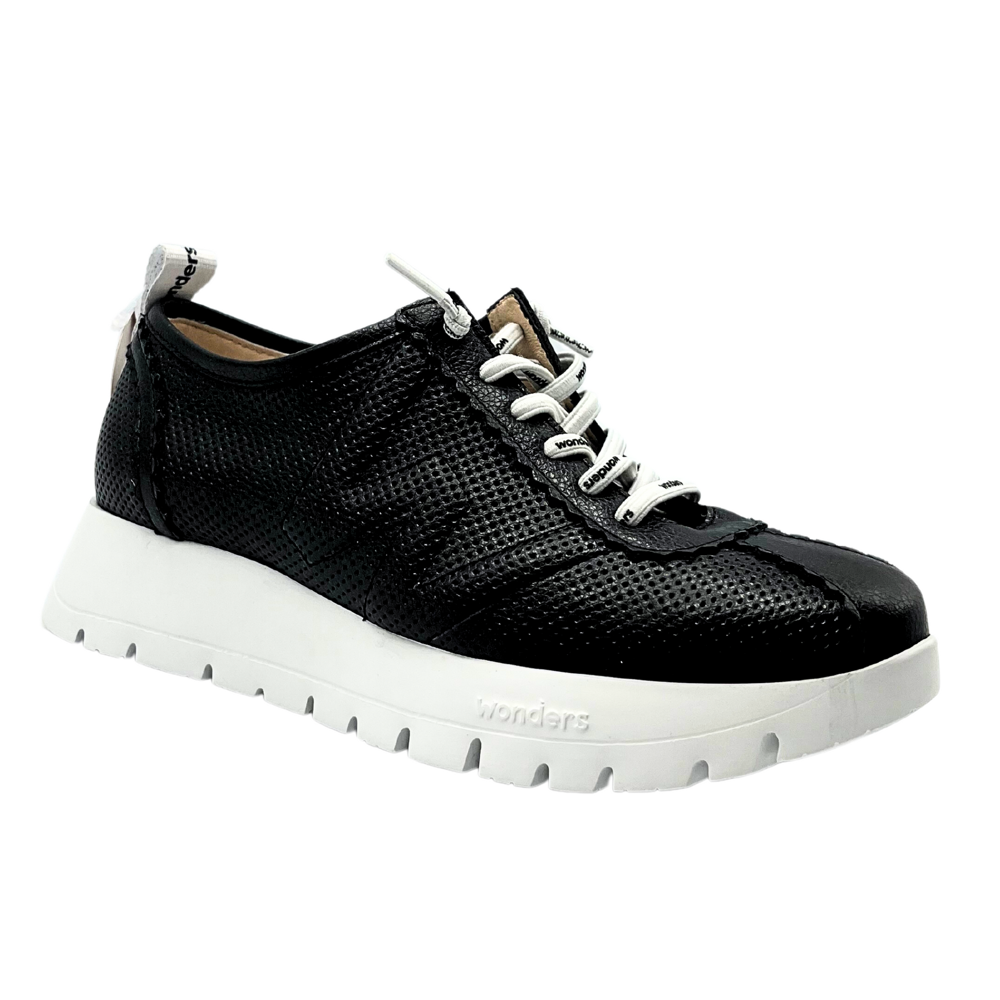 Outside view of a black leather sandal with white sole and white laces.  Black leather has tiny laser circle cut outs around all but the toe where it is smooth