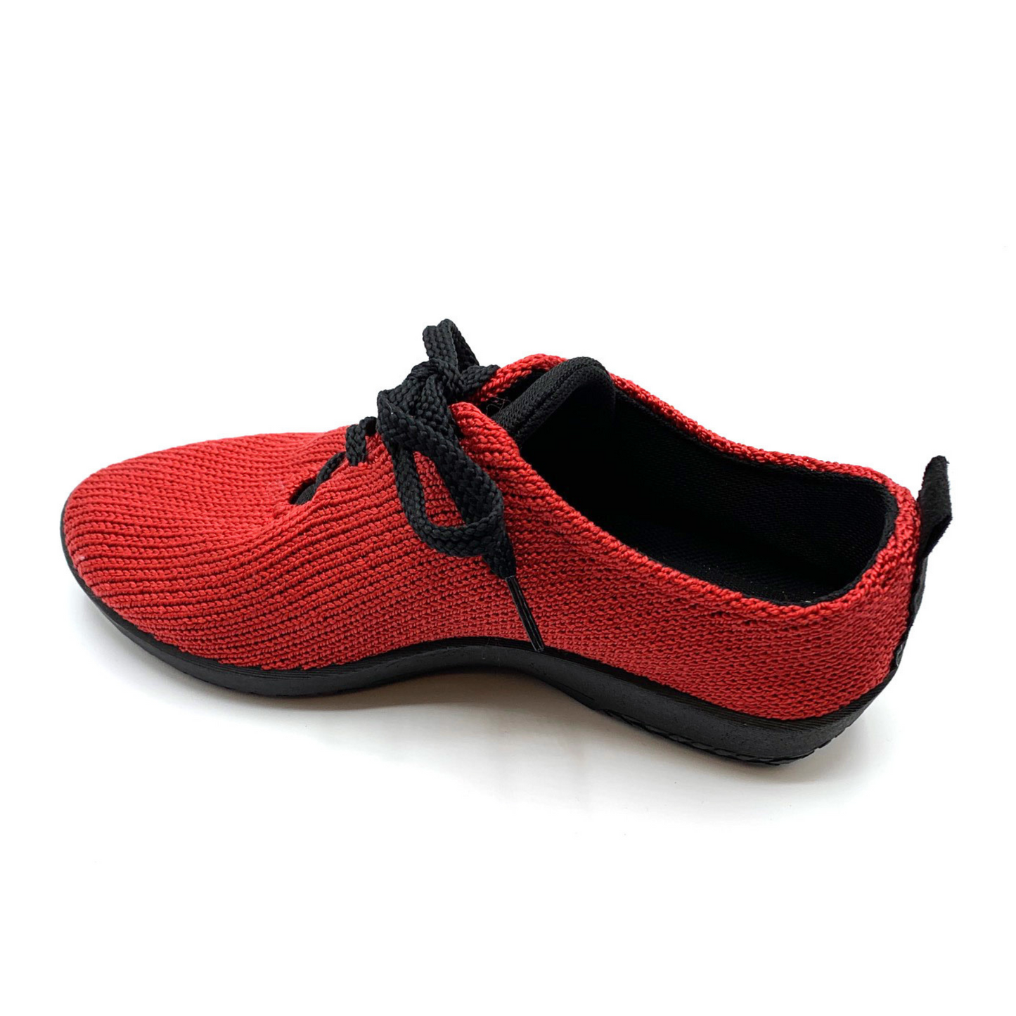 Knit red sneaker at a slight back angle showing interior black lining, sole, and shoe strings.