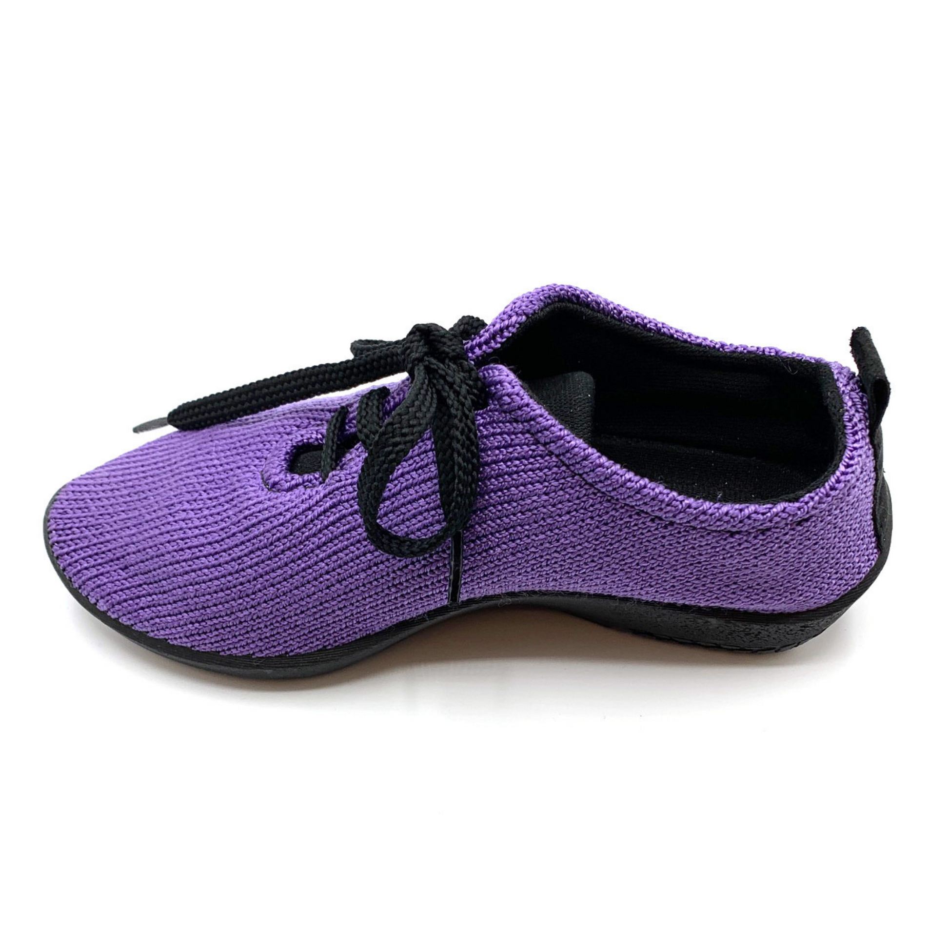 Purple sneaker pictured in profile featuring knit upper, black sole, lining, and black shoe strings.