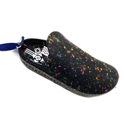 A multicoloured black fleted shoe is pictured at an angle showing neon pink, orange, blue, and yellow speckles dotted across the upper. The sole is a black and cork mixed material with a white geometric pattern in the sole.