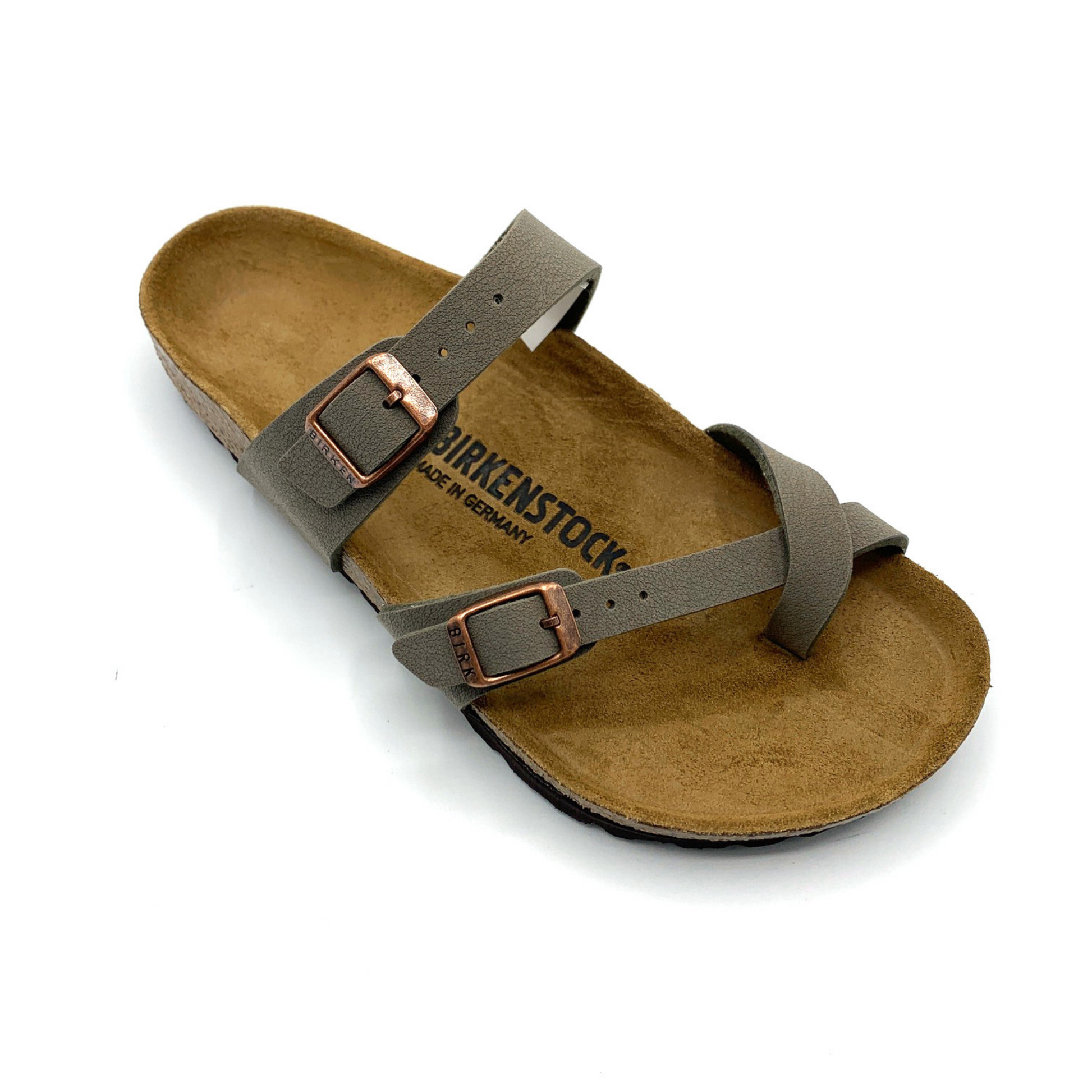 A 45 degree angle view of a sandal with a caramel-brown cork sole, two grey straps, and copper coloured buckles. One of the straps goes over the upper part of the foot, and the other goes between the toes.