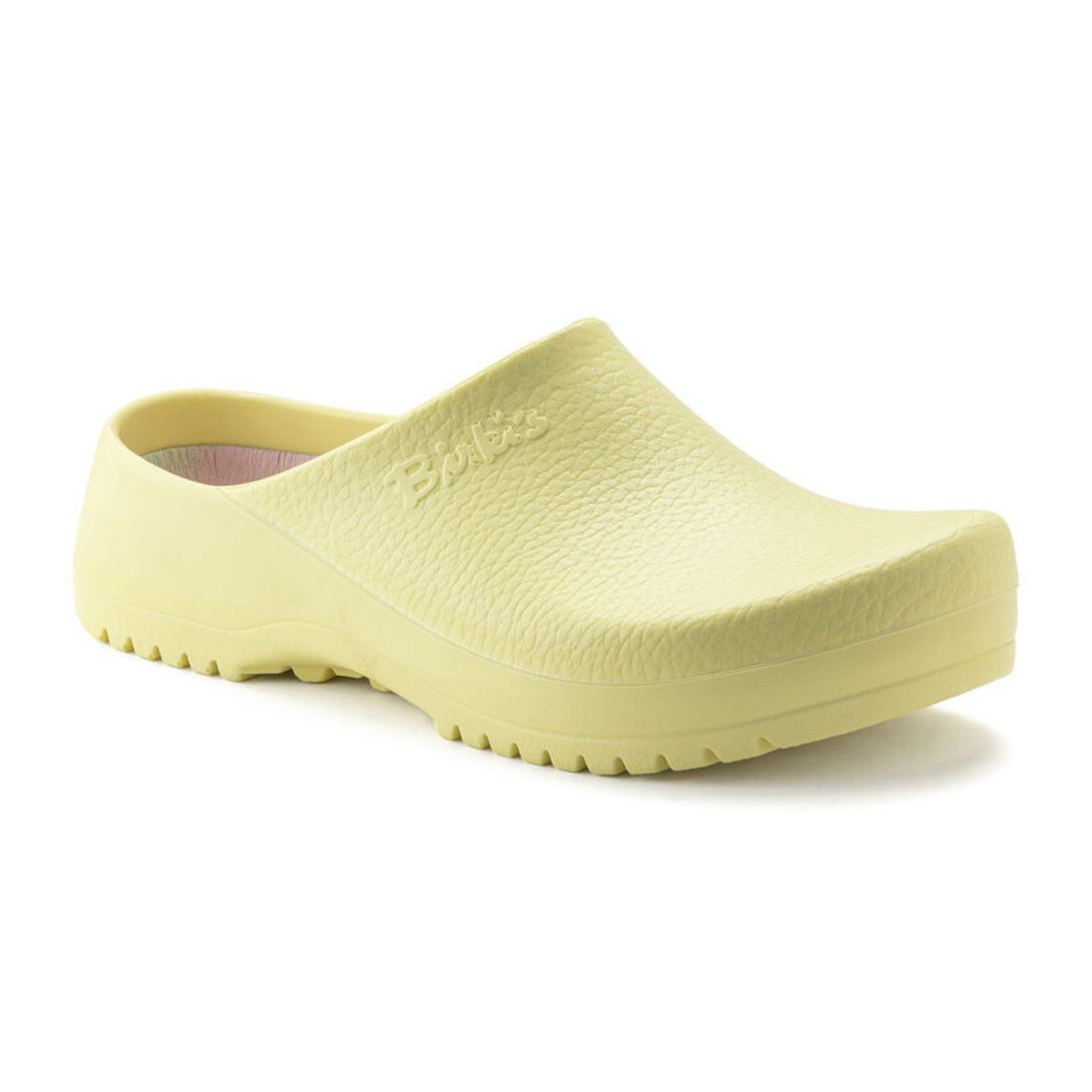 A 45 degree angle view of a pale yellow clog with a grippy bottom and colourful insole.