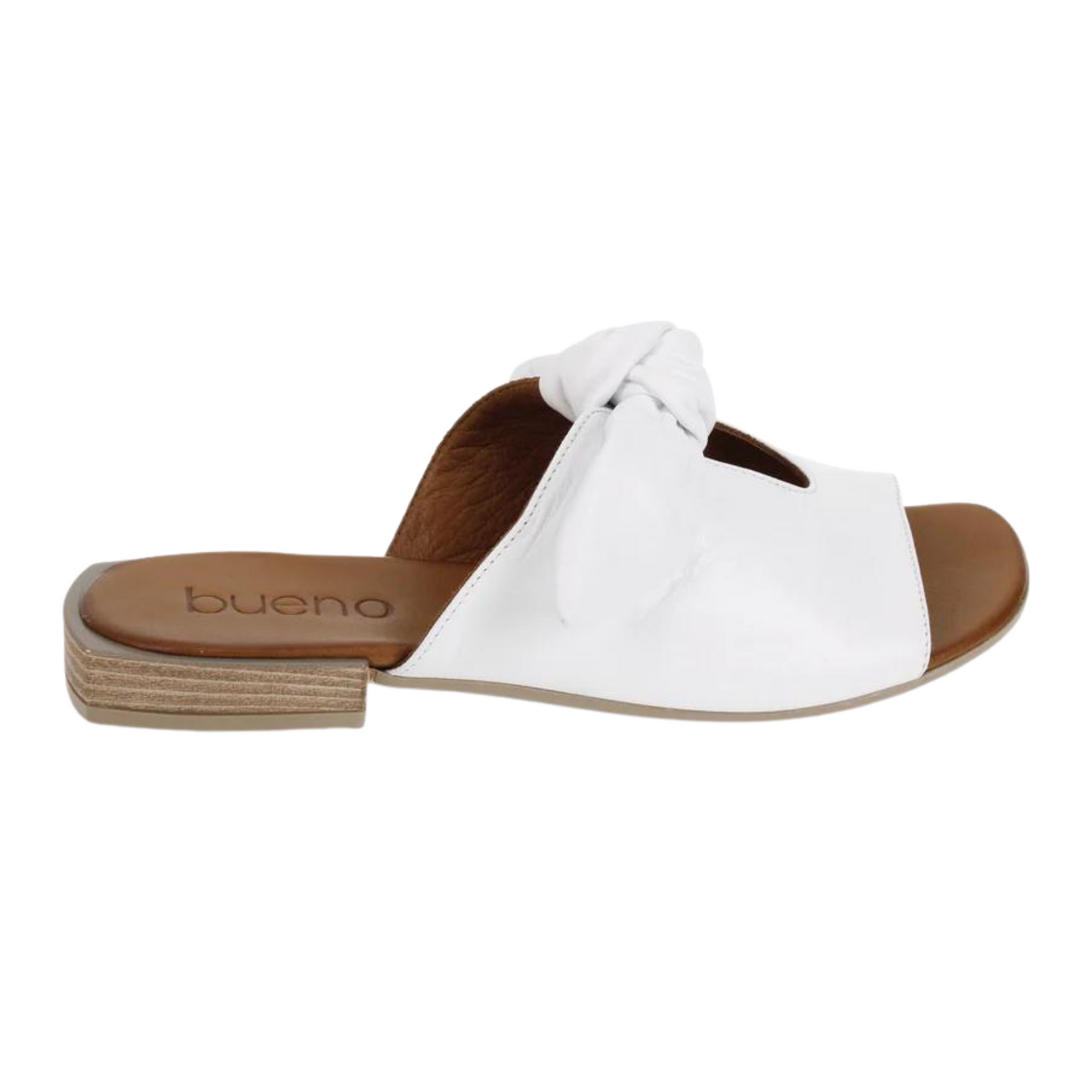 The white leather sandal is pictured in profile showing the midfoot strap with centre cutout, white bow tie band, brown leather sole, and short block heel.