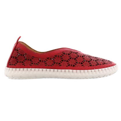 The red sneaker slip on is pictured in profile showing the delicate flower pattern made through cut outs. The white sole is stitched to the upper with white thread, and a red heel tab pokes up at the back.