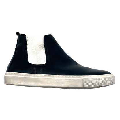 A black leather boot style sneaker features white elastic ankles and an off-white sole.