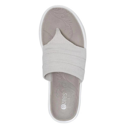 The top of a Y strap sandal is pictured featuring a grey footbed with engraved floral design.