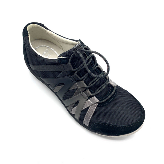 A black sneaker viewed from a 45 degree angle. The shoe has black cord-like laces, a mesh top, suede detailing, and an Ombre zig-zagged side pattern.