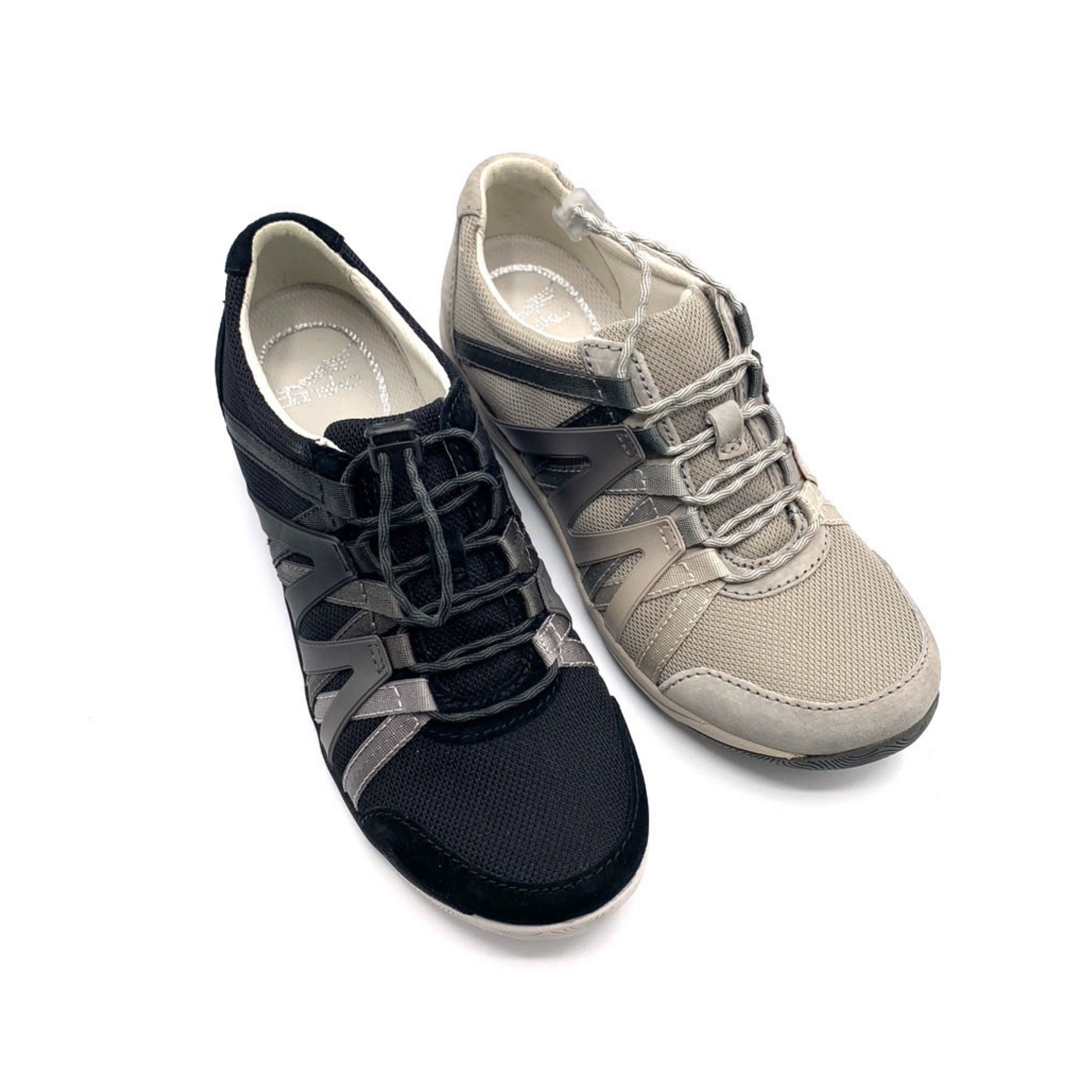 Two sneakers, one black and the other warm grey, viewed from a 45 degree angle. Both shoes have a mesh top, suede detailing, and an Ombre zig-zagged side pattern.