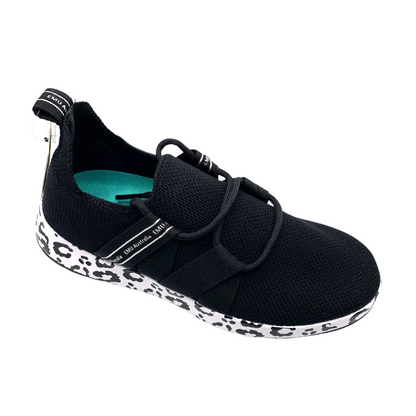 A right angle view of a black sneaker with a leopard print sole.