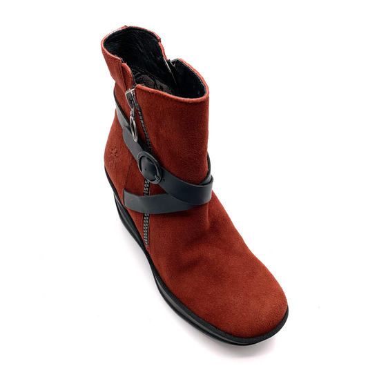 A top angled view of a soft, red leather boot with a wedged black rubber sole, a silver zipper up the side, and crossing black leather straps around the front.