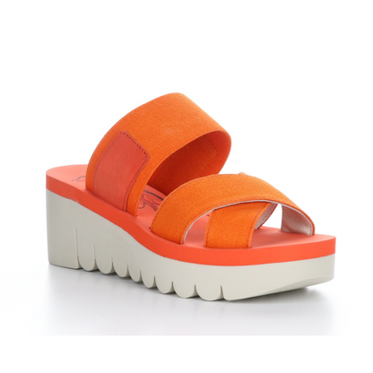 A 45 degree angle view of a red-orange platform wedged sandal with a white outsole.