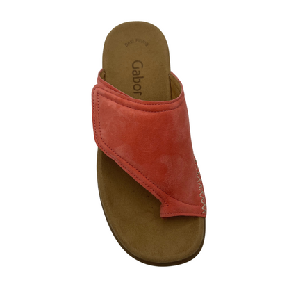 A top view of a light red suede toe loop sandal.