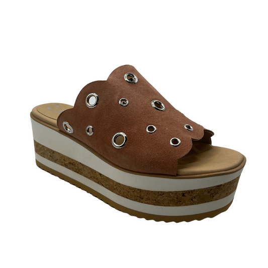 A right angle view of a brown suede platform slide with circular cutouts.
