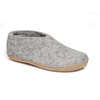 A felted light grey tall-back slipper pictured at a slight angle, showing part of the top front and side of the slipper. A tan leather sole lines the bottom of the shoe with a row of stitching.