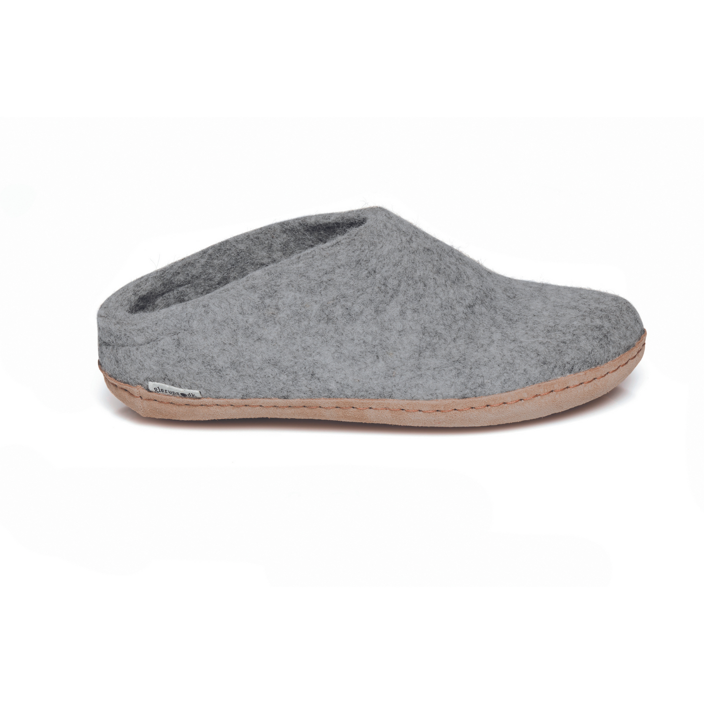 A light grey slipper is pictured in profile, showing the low back of the heel. The bottom lined in tan leather has a small tag with the brand name attached in the seam where the leather meets the felted wool.