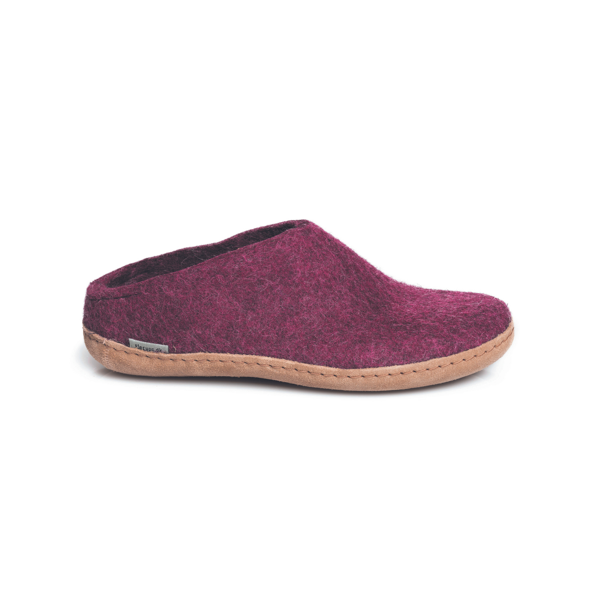 A deep-mauve slipper is pictured in profile, showing the low back of the heel. The bottom lined in tan leather has a small tag with the brand name attached in the seam where the leather meets the felted wool.