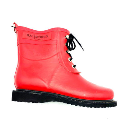 A right side view of a red rain boot with black details.