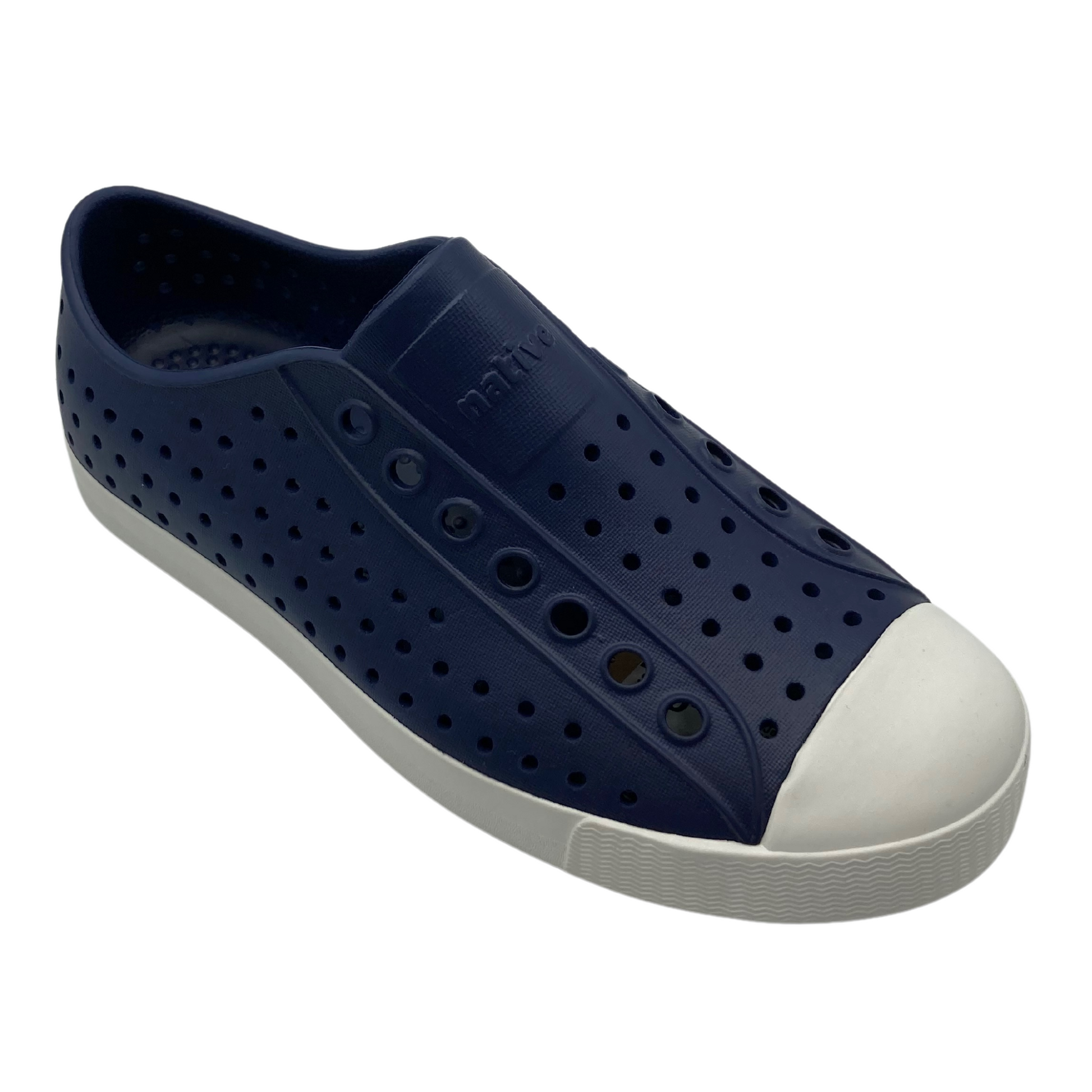 A dark navy sneaker with perforations and a white toe box and sole is pictured at a slight angle.