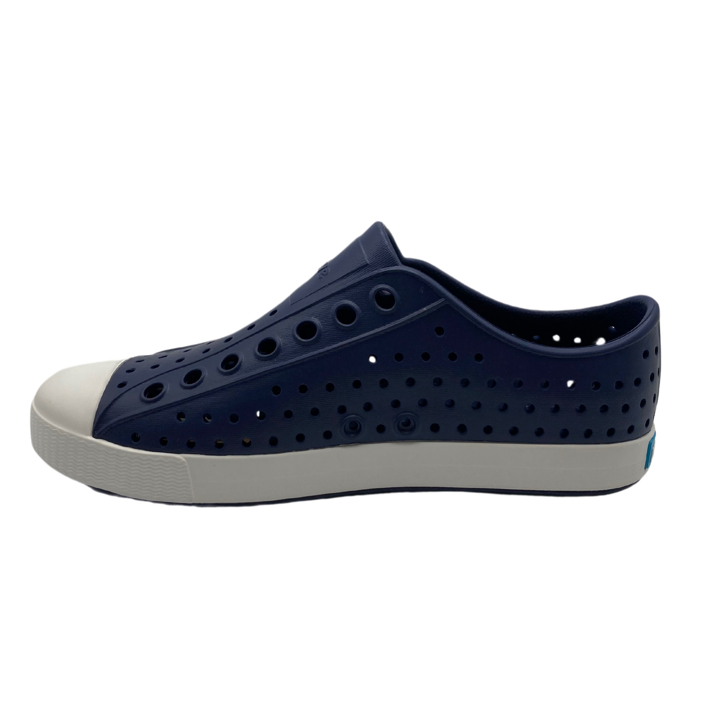 A dark navy sneaker is pictured in profile, showing rows of perforations and a white toe box and sole.