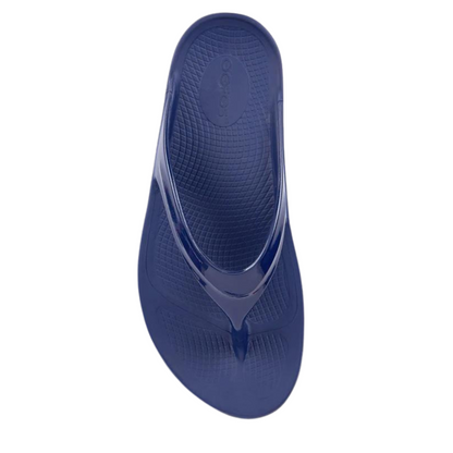 A top view of a navy foam sandal with a single between-toe strap and grippy sole.
