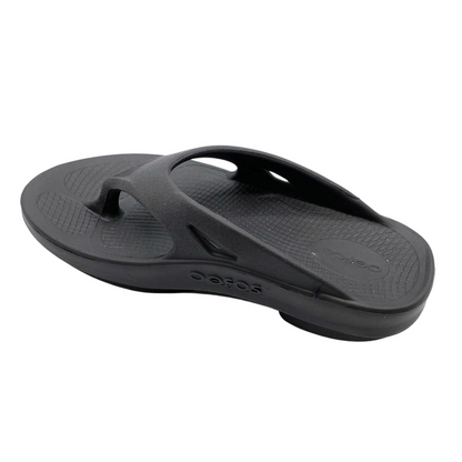 A left angle view of a black foam sandal with a between-toe strap.
