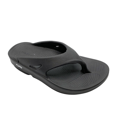 A right angle view of a black foam sandal with a between-toe strap.