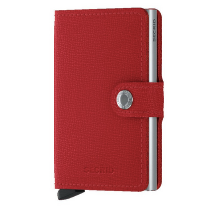 A photo of the wallet in the colour crisple red. This photo shows the texture of the wallet and the strap to secure it closed.