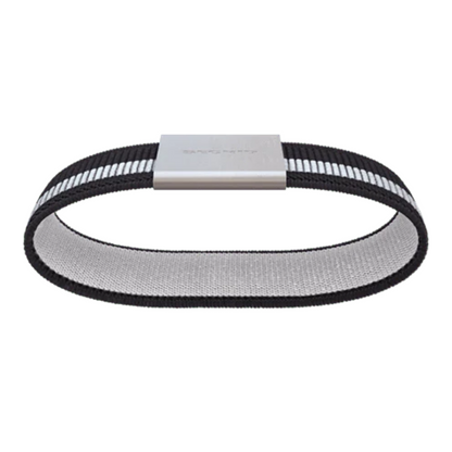 The black and white band is pictured from below revealing the light grey lining. The silver metal buckle sits on the top of the loop.