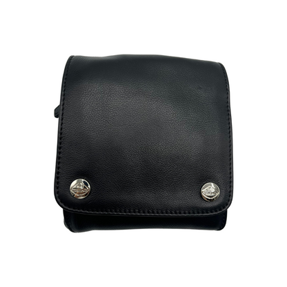 The front of a black leather bag, with a square face and two shiny silver metal buttons, each bearing "The Trend" logo.