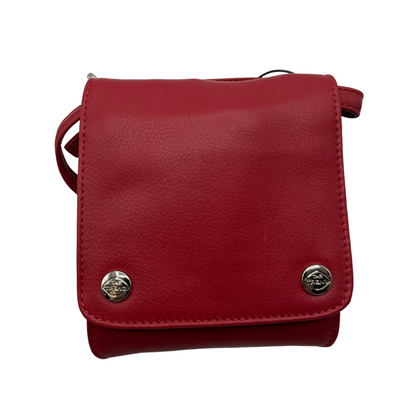 The front of a red leather bag, with a square face and two shiny silver metal buttons, each bearing "The Trend" logo.