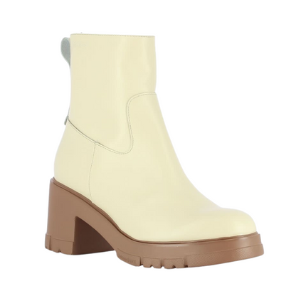 A right angle view of a cream coloured leather boot with a caramel coloured outsole.
